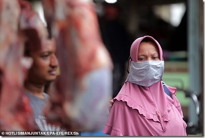 27652152-8257375-An_Indonesian_woman_R_wears_a_hand_made_protective_masks_while_b-a-7_1587857843612